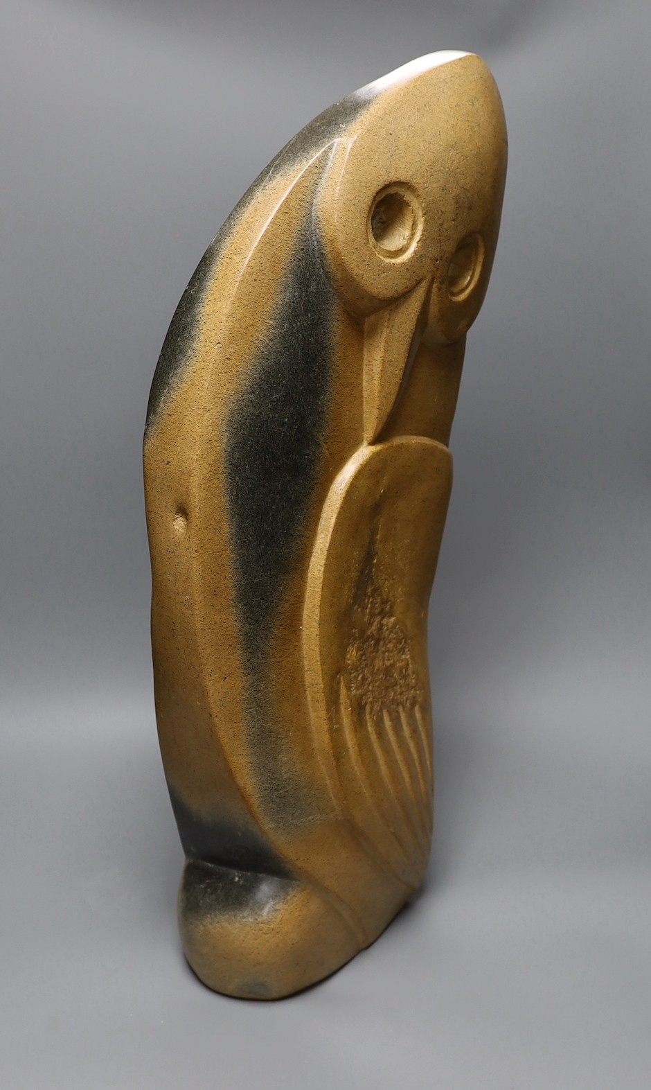 A Zimbabwean carved and polished stone figure of a stylised winged bird, with a long neck. 64cm